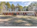 Brick ranch house with stone accents, large yard, and mature trees at 129 Jeffress Dr, Louisburg, NC 27549