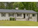 Charming ranch home with a painted brick facade, complemented by black shutters and a well-manicured lawn at 129 Jeffress Dr, Louisburg, NC 27549