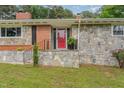 A closer view of the stone porch with black railings and a vibrant red front door at 129 Jeffress Dr, Louisburg, NC 27549