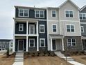 Two-story townhome with gray and beige siding, steps, and landscaping at 1309 Hazelnut Ridge Ln, Knightdale, NC 27545