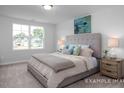 Bright bedroom features a plush bed, neutral decor and a view of the neighborhood at 3934 Well Fleet Drive, Fuquay Varina, NC 27526