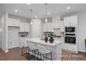Modern kitchen with stainless appliances, white cabinetry and a large center island with seating at 3934 Well Fleet Drive, Fuquay Varina, NC 27526