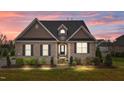 Inviting home exterior with illuminated landscape, brick facade, and cozy curb appeal at 4236 Aviemore, Burlington, NC 27215