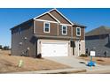 Two-story house with beige and brown siding, a white garage door, and a small front yard at 65 White Birch Ln, Angier, NC 27501