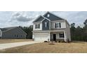 Two story home featuring blue and grey siding, attached two-car garage and minimal landscaping at 165 Knoll Way, Sanford, NC 27332