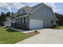 Side exterior view featuring a two-car garage and well maintained lawn at 200 Ironwood Lot 39 Blvd, Youngsville, NC 27596