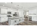 Open concept kitchen featuring white cabinets, granite island, and wine cooler at 418 Providence Springs Ln, Fuquay Varina, NC 27526