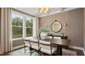 Bright dining room featuring a large table, chandelier, and view of the backyard at 902 Brookfield Dr, Gibsonville, NC 27249