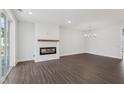 Bright living room with a modern fireplace, stylish chandelier, and sliding glass doors at 11548 Helmond Way # 118, Raleigh, NC 27617