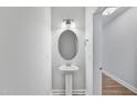 A minimalist powder room features a pedestal sink and an oval mirror at 538 Eversden Dr, Zebulon, NC 27597