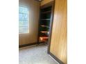 Room featuring wood paneling, vintage flooring, a window, and built-in shelving at 420 E Hinton St, Clayton, NC 27520
