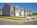 Street view of new townhomes with single-car garages, lush lawns and visitor parking at 305 Cherry Laurel Dr, Sanford, NC 27332