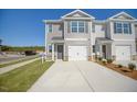 Newly constructed townhome showcases a single-car garage, manicured lawn and convenient driveway at 305 Cherry Laurel Dr, Sanford, NC 27332