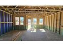 A bright, unfinished room featuring stud-framing, future window views, and open access to the outdoors at 3852 Well Fleet Drive, Willow Springs, NC 27592