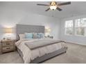 Bright bedroom featuring a large bed, soft carpet, and windows providing ample natural light at 3856 Well Fleet Drive, Fuquay Varina, NC 27526