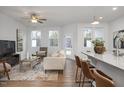 Cozy living room with stylish seating, a large TV, and a breakfast bar that connects to the kitchen at 3856 Well Fleet Drive, Fuquay Varina, NC 27526
