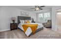Sunlit bedroom features neutral tones, carpet, ceiling fan, ensuite bath, and sunny windows at 3930 Well Fleet Drive, Fuquay Varina, NC 27526