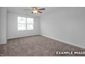 Bright bedroom featuring plush carpeting, ceiling fan, and a large window for ample natural light at 3932 Well Fleet Drive, Fuquay Varina, NC 27526