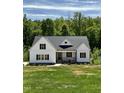 Charming new construction with a covered porch, white siding and black shutters on a lush green lot at 40 Moonraker Dr, Spring Hope, NC 27882