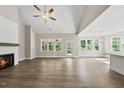 Bright living room with vaulted ceiling, a cozy fireplace, hardwood floors, and large windows overlooking the backyard at 40 Moonraker Dr, Spring Hope, NC 27882