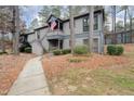 Two-story condominium with an American flag, gray siding, and a concrete walkway at 42 Melstone Turn, Durham, NC 27707
