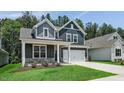 Charming two-story home featuring a two-car garage, gray siding, stone accents, and a well-manicured lawn at 7537 Percussion Dr, Apex, NC 27539