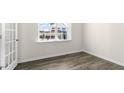 Well-lit room featuring a window, neutral walls, and wood-look flooring at 420 Blue Aspen Dr, Fuquay Varina, NC 27526