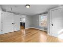 Sunlit bedroom boasts gleaming hardwood floors, complemented by light gray walls and two doors with white trim at 826 Carter Ave, Durham, NC 27703