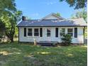 Cozy home with black shutters, a new roof, landscaped yard, and a welcoming front porch at 826 Carter Ave, Durham, NC 27703