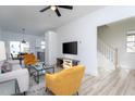 Open living room with stylish furniture, a ceiling fan, hardwood floors, and staircase at 110-A S Hyde Park Ave, Durham, NC 27703