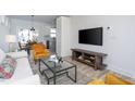 Contemporary living room with mounted TV, modern furniture, and adjacent dining area at 110-A S Hyde Park Ave, Durham, NC 27703