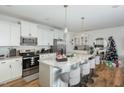 Bright kitchen with white cabinets, stainless steel appliances, and a large island with barstool seating at 236 George Pine Way, Knightdale, NC 27545