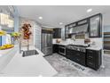 Modern kitchen features stainless steel appliances, wine rack, and black cabinets with white countertops at 5705 Katha Dr, Holly Springs, NC 27540