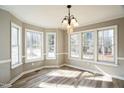 Sunlit dining area with hardwood floors, large windows, and an elegant chandelier at 309 Monterey Ct, Benson, NC 27504