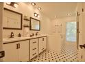 Bright bathroom with double vanities, modern fixtures, and a classic black and white tiled floor at 340 Andrews Store Rd, Pittsboro, NC 27312