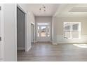 Bright entryway with gorgeous gray wood floors, complemented by a chandelier and natural light from large windows at 563 Glenkirk Pl # 104, Garner, NC 27529