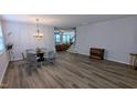 Open concept dining area with modern chandelier and hardwood floors at 101 Clardona Way, Holly Springs, NC 27540