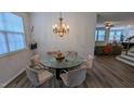 Modern dining area with large glass table, chandelier and hardwood floors at 101 Clardona Way, Holly Springs, NC 27540