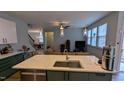 Kitchen island with a sink, faucet and stainless-steel dishwasher offers seating and an open concept living space at 101 Clardona Way, Holly Springs, NC 27540