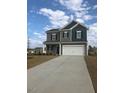 Attractive gray two-story home with a two-car garage and a concrete driveway on a partially cloudy day at 120 Vili Dr, Broadway, NC 27505