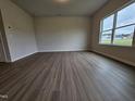 Spacious living room with wood-look floors, a large window offering plenty of light, and neutral color walls at 120 Vili Dr, Broadway, NC 27505