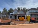 New home construction with visible frame; construction equipment and building supplies present at 2155 Pink Peony Cir # 235, Durham, NC 27703