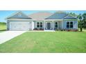Charming single-story home with a well-manicured lawn, a two-car garage and stone accents at 587 Glenkirk Pl, Garner, NC 27529