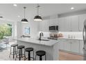 Sleek kitchen boasts a quartz island, modern pendant lighting, and all-white cabinetry at 612 Rocky Knob Ct, Raleigh, NC 27601