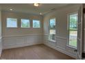 Dining room with hardwood floors, lots of light from the large windows and white trim at 243 Kissington Way, Benson, NC 27504