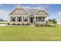 Inviting single-story home with a well-maintained lawn and a welcoming front porch at 243 Kissington Way, Benson, NC 27504