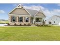 Beautiful single-story home with stone accents, manicured lawn, and an inviting front porch at 243 Kissington Way, Benson, NC 27504
