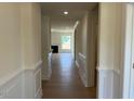 Hallway with wood-look flooring leading to the living area with lots of natural light at 243 Kissington Way, Benson, NC 27504