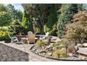 Landscaped backyard with stone patio, outdoor seating and tranquil water feature, perfect for relaxation at 2526 Snowdrop Ct, Apex, NC 27502
