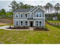 Classic gray two-story home with bright white-trim windows, complemented by a lush green lawn at 367 Duncan Creek Rd # 129, Lillington, NC 27546